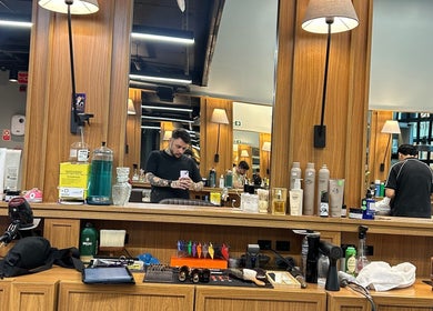 Interior da barbearia Vinnie Torriton Men em Paraná, Paraná, BR com espelhos e produtos de beleza.