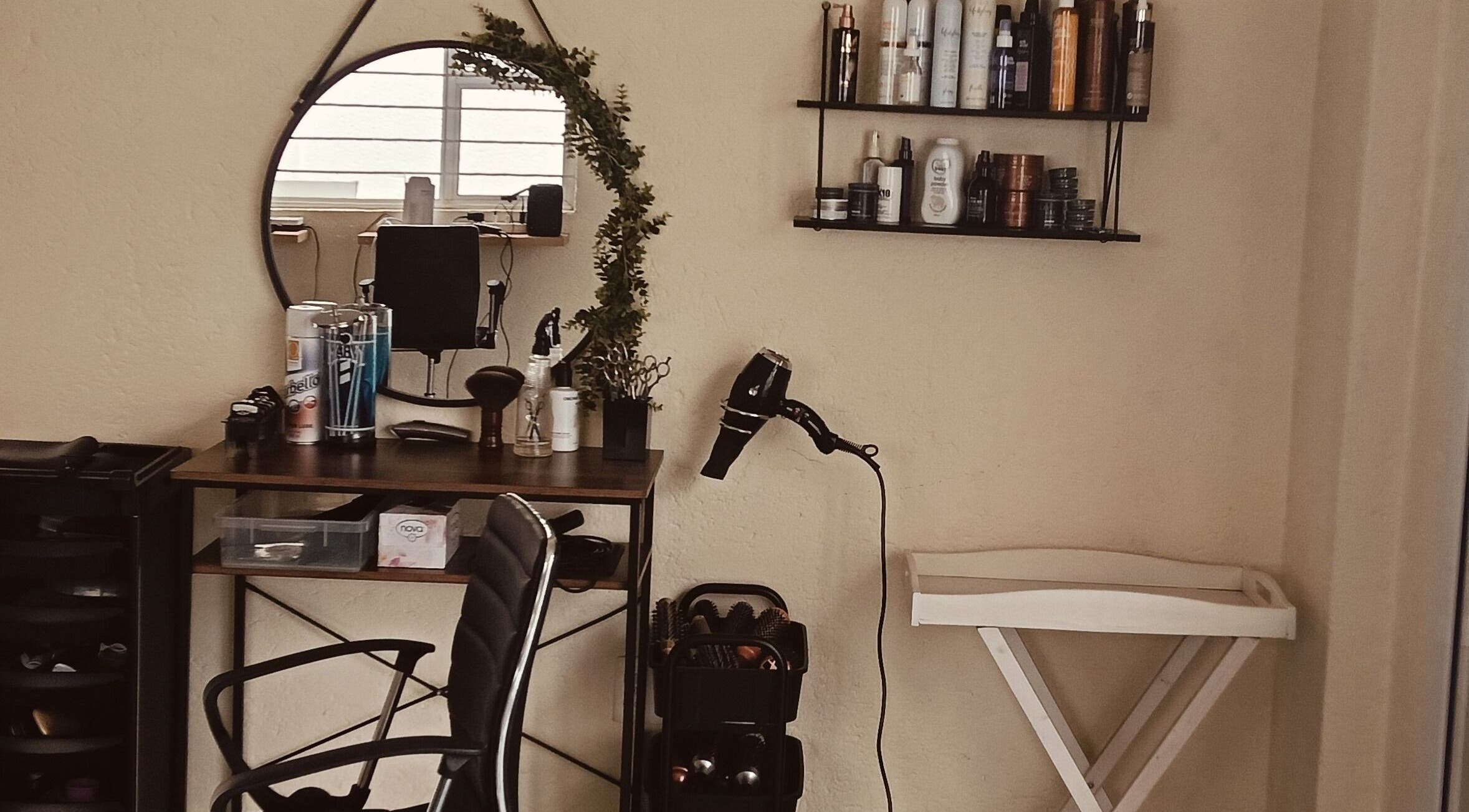 Cozy styling station at Solace Hair, Sandton, Gauteng, ZA, with mirror, products, and chair.