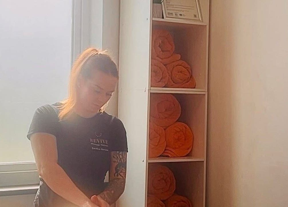 Therapist at Revive Massage Therapy, Guernsey Vale GG, preparing for a calming session with rolled towels.
