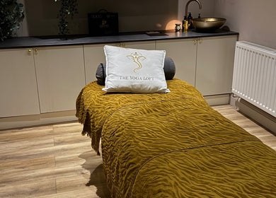 Elegant therapy room at Sportstherapybygeorgia, Prescot, England, GB with a plush golden bedspread and soft lighting.