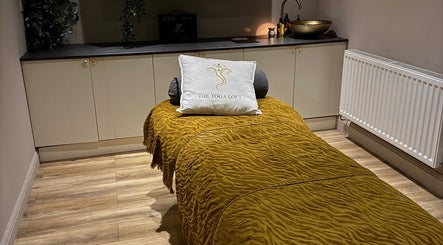 Elegant therapy room at Sportstherapybygeorgia, Prescot, England, GB with a plush golden bedspread and soft lighting.