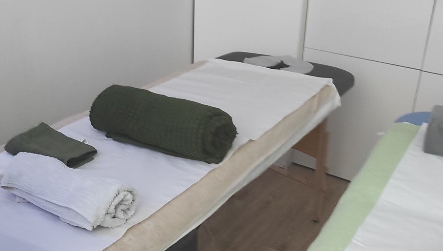 Table de massage chez Janesophrologue à Paris, Île-de-France. Draps et serviettes bien disposés.