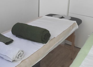 Table de massage chez Janesophrologue à Paris, Île-de-France. Draps et serviettes bien disposés.