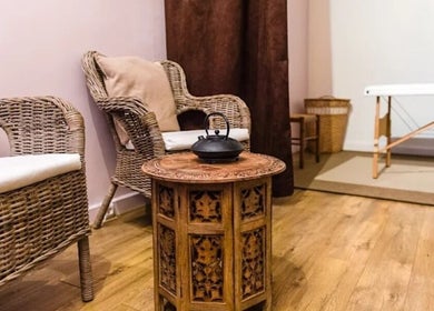 Intérieur chaleureux chez Janesophrologue, Paris, Île-de-France, FR. Mobilier en osier et table sculptée.