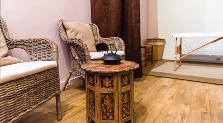 Intérieur chaleureux chez Janesophrologue, Paris, Île-de-France, FR. Mobilier en osier et table sculptée.