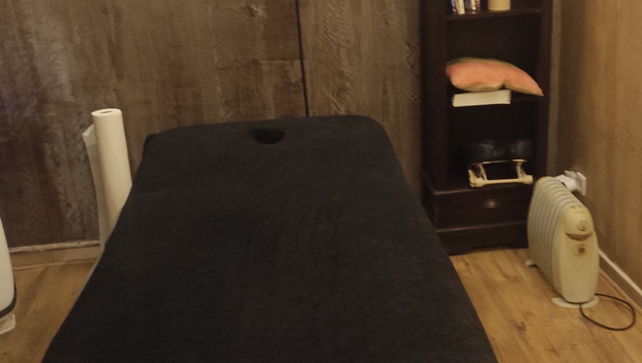 Salle de massage confortable chez Janesophrologue à Paris, Île-de-France, FR avec table et étagère.