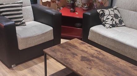 Coin salon élégant chez Janesophrologue, Paris, Île-de-france, FR, avec fauteuils et table en bois.