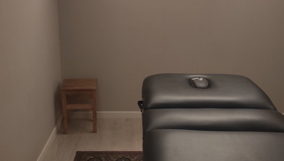 Salle de soin apaisante chez Janesophrologue à Paris, Île-de-France, FR avec une table de massage noire.