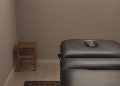 Salle de soin apaisante chez Janesophrologue à Paris, Île-de-France, FR avec une table de massage noire.