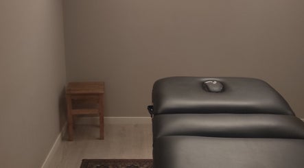 Salle de soin apaisante chez Janesophrologue à Paris, Île-de-France, FR avec une table de massage noire.