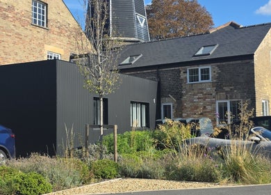 Exterior view of STUDIO19, Cambridge, England, GB showcasing modern design and lush landscaping.