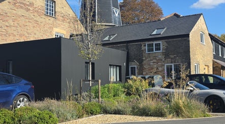 Exterior view of STUDIO19, Cambridge, England, GB showcasing modern design and lush landscaping.