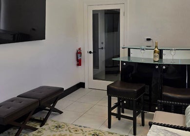 Elegant lounge at K Day Spa, Naples, Florida, US, featuring a stylish bar area with stools and modern decor.