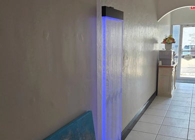 Serene hallway with a blue-lit feature at K Day Spa, Naples, Florida, US.