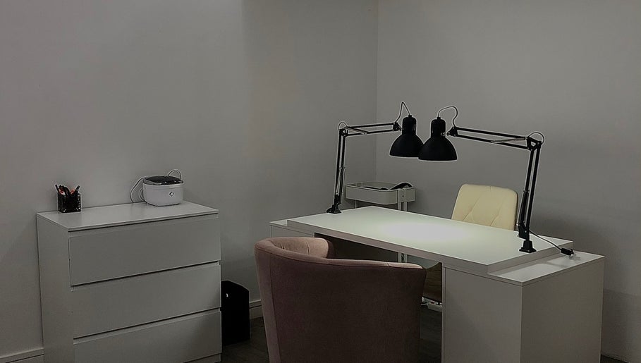 Bureau moderne chez EmiNails à Libourne, Nouvelle-aquitaine, FR avec chaise rose et lampe noire.