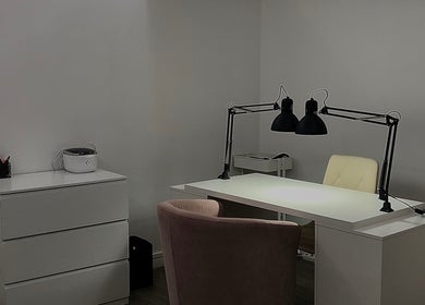 Bureau moderne chez EmiNails à Libourne, Nouvelle-aquitaine, FR avec chaise rose et lampe noire.