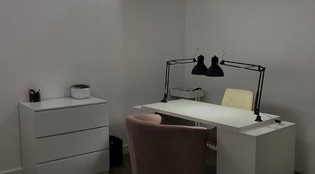 Bureau moderne chez EmiNails à Libourne, Nouvelle-aquitaine, FR avec chaise rose et lampe noire.