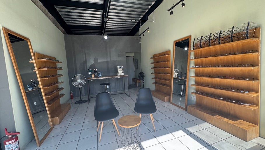Sala de óptica en Lentelopolis Fontana, San Pedro Tlaquepaque, Jalisco, MX, con sillas y estantes de gafas.