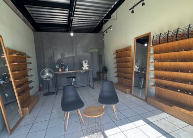 Sala de óptica en Lentelopolis Fontana, San Pedro Tlaquepaque, Jalisco, MX, con sillas y estantes de gafas.