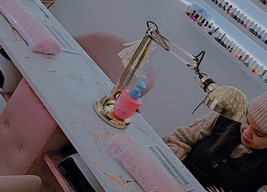 Nail technician at Gs beauty salon in Porto, PT, providing manicure service amidst elegant decor.