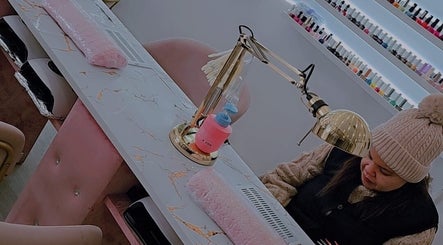 Nail technician at Gs beauty salon in Porto, PT, providing manicure service amidst elegant decor.