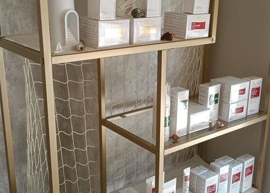 Productos de belleza en estante dorado en Paula Mardones - Estética Integral, Logroño, La Rioja, ES.