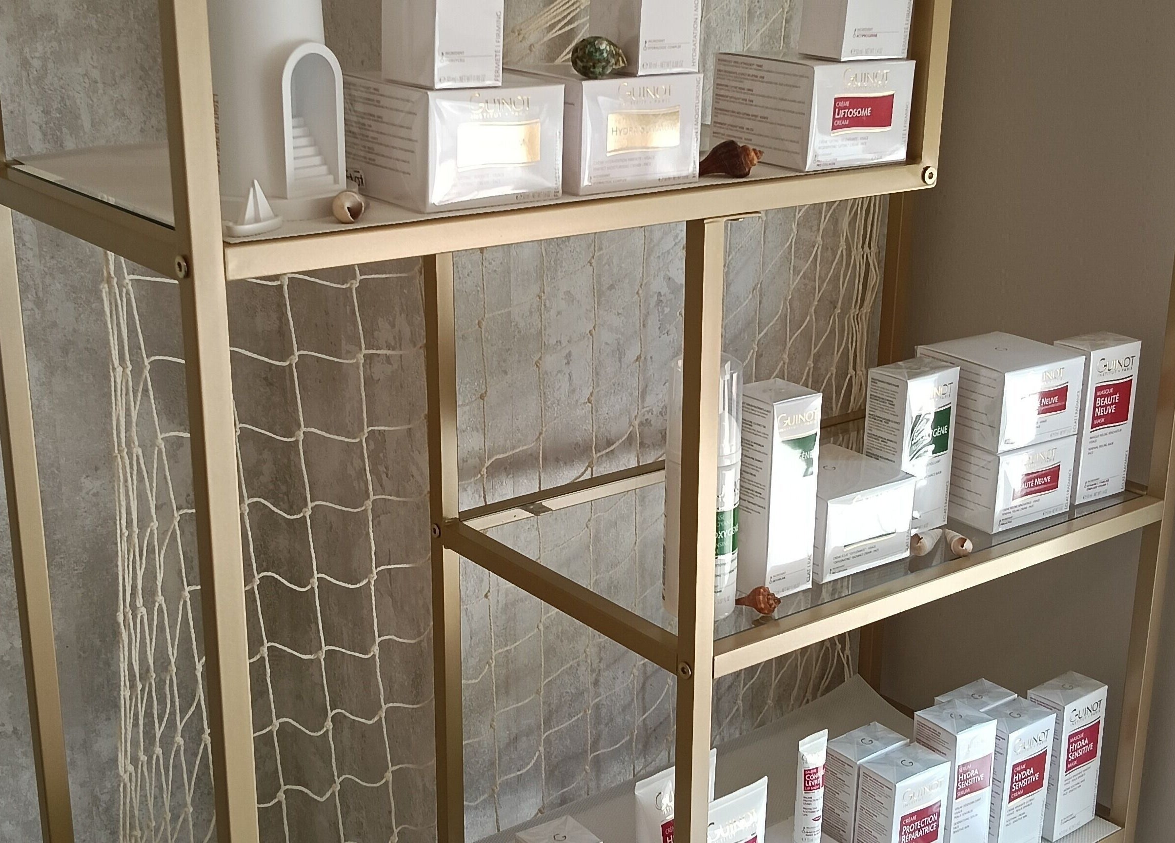 Productos de belleza en estante dorado en Paula Mardones - Estética Integral, Logroño, La Rioja, ES.