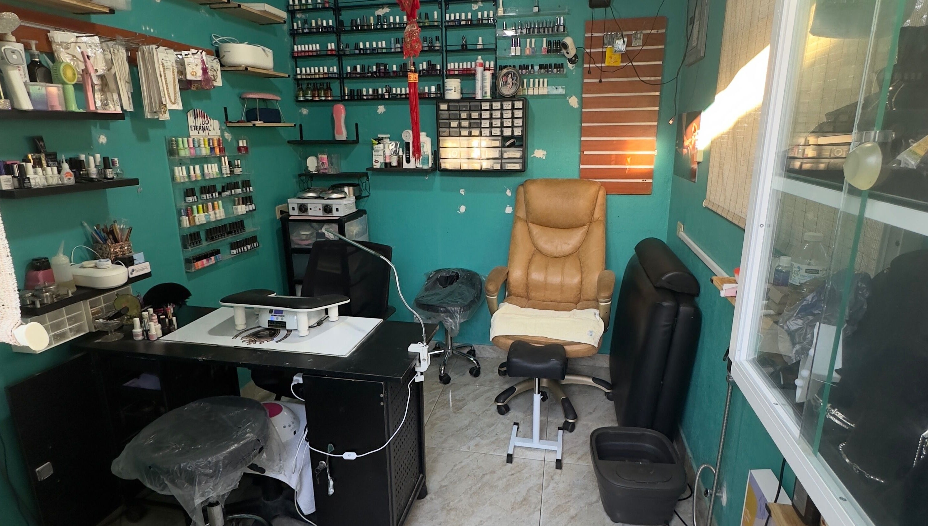 Cozy nail care area at JPOSH, Portmore, St. Catherine Parish, JM, with nail polish display and plush seating.