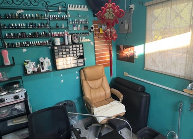JPOSH salon interior in Portmore, St. Catherine Parish, JM with a cozy chair and vibrant wall decor.