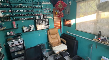 JPOSH salon interior in Portmore, St. Catherine Parish, JM with a cozy chair and vibrant wall decor.