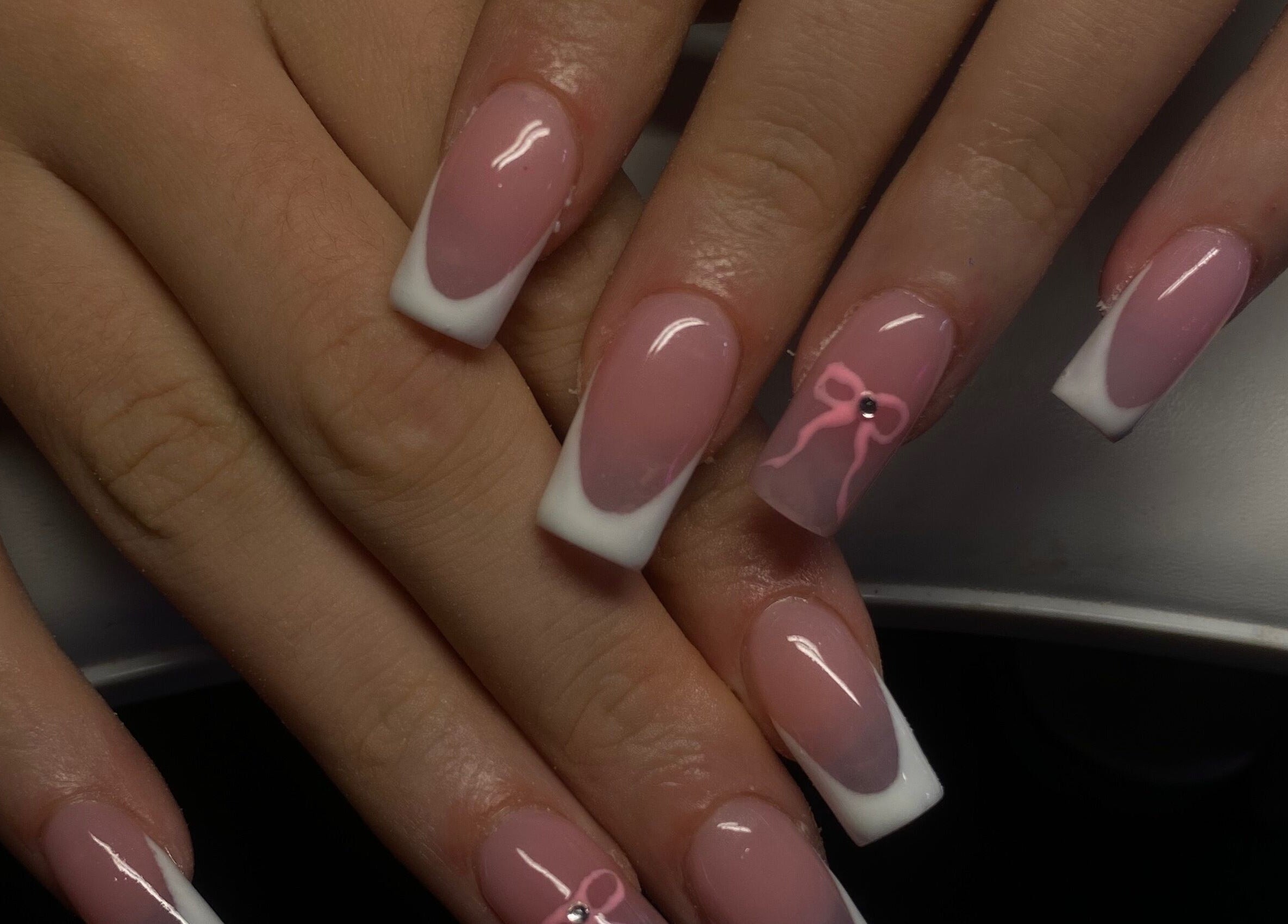 Elegant pink and white acrylic nails at TheNailBoy, Aberdeen, Scotland, GB, with stylish bow design.