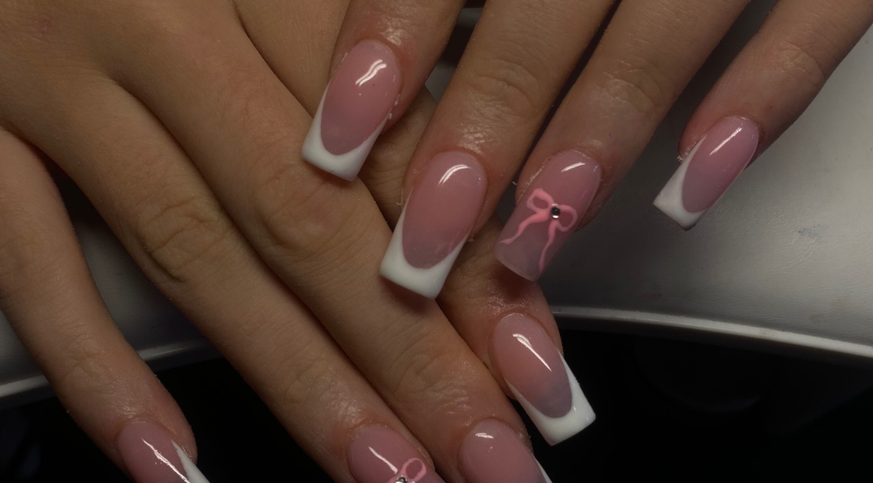 Elegant pink and white acrylic nails at TheNailBoy, Aberdeen, Scotland, GB, with stylish bow design.