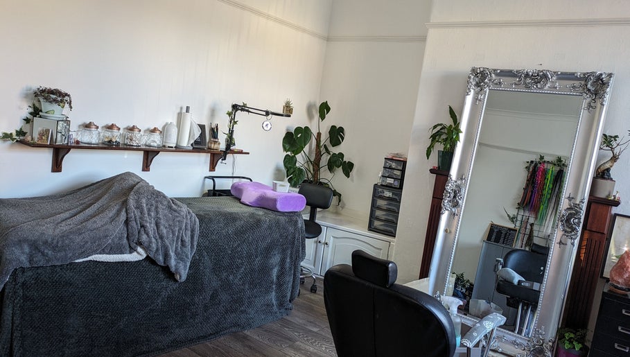 Calming treatment room at Foxglove Beauty in Radcliffe, England, GB, featuring plush massage bed and ornate mirror.