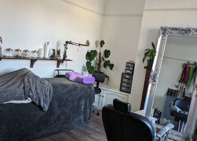 Calming treatment room at Foxglove Beauty in Radcliffe, England, GB, featuring plush massage bed and ornate mirror.