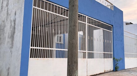 Front exterior of Street 7z Barbers, featuring a blue wall and white bars at La Curva, Tabasco, MX.