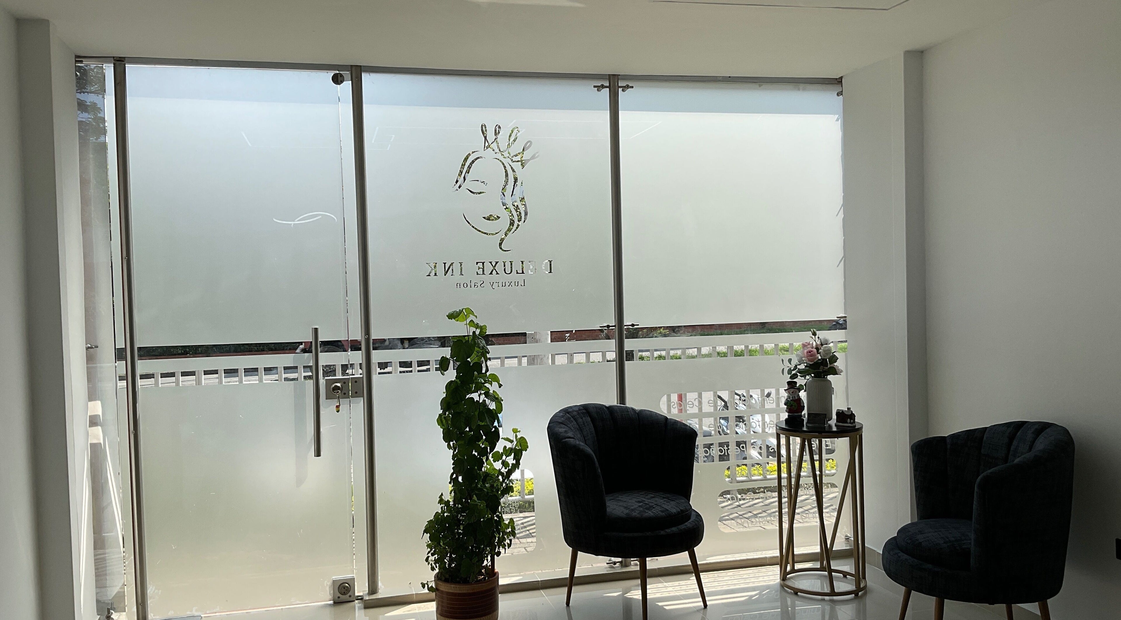 Chic seating area in DeLuxe Ink, Cali, Valle Del Cauca, CO with frosted glass and stylish decor.