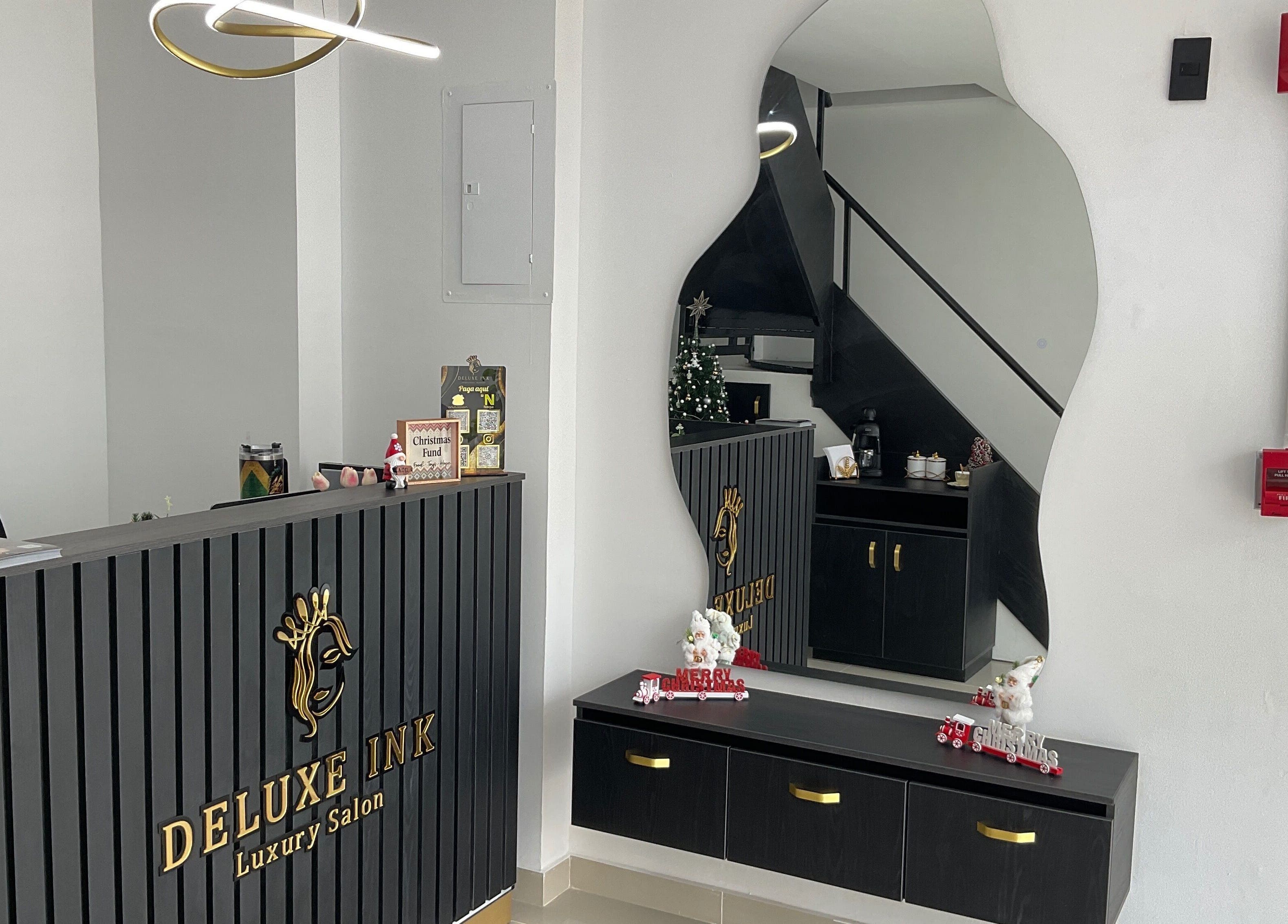 Reception area at DeLuxe Ink, a luxury salon in Cali, Valle Del Cauca, CO with modern decor and artistic mirror.