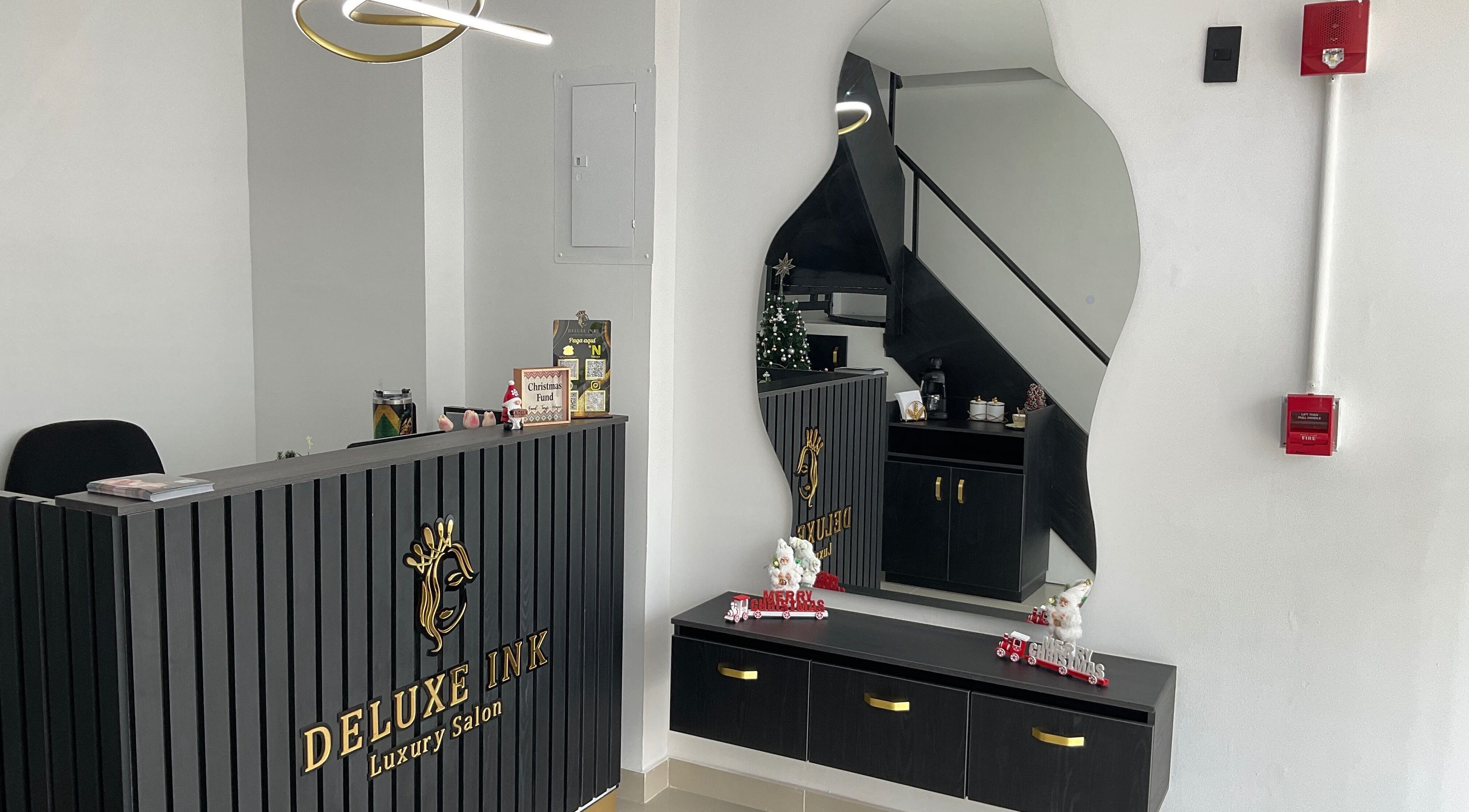 Reception area at DeLuxe Ink, a luxury salon in Cali, Valle Del Cauca, CO with modern decor and artistic mirror.