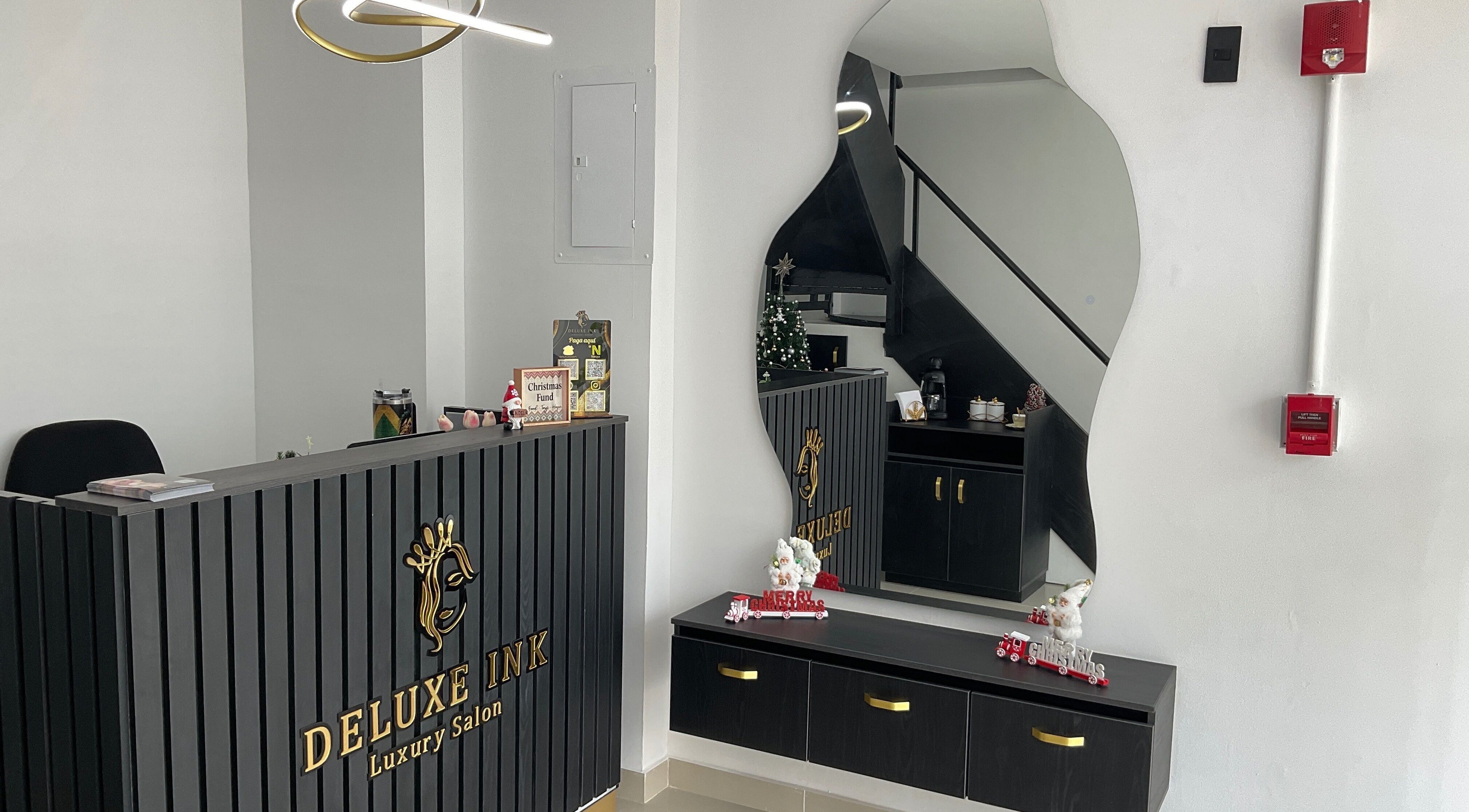 Reception area at DeLuxe Ink, a luxury salon in Cali, Valle Del Cauca, CO with modern decor and artistic mirror.