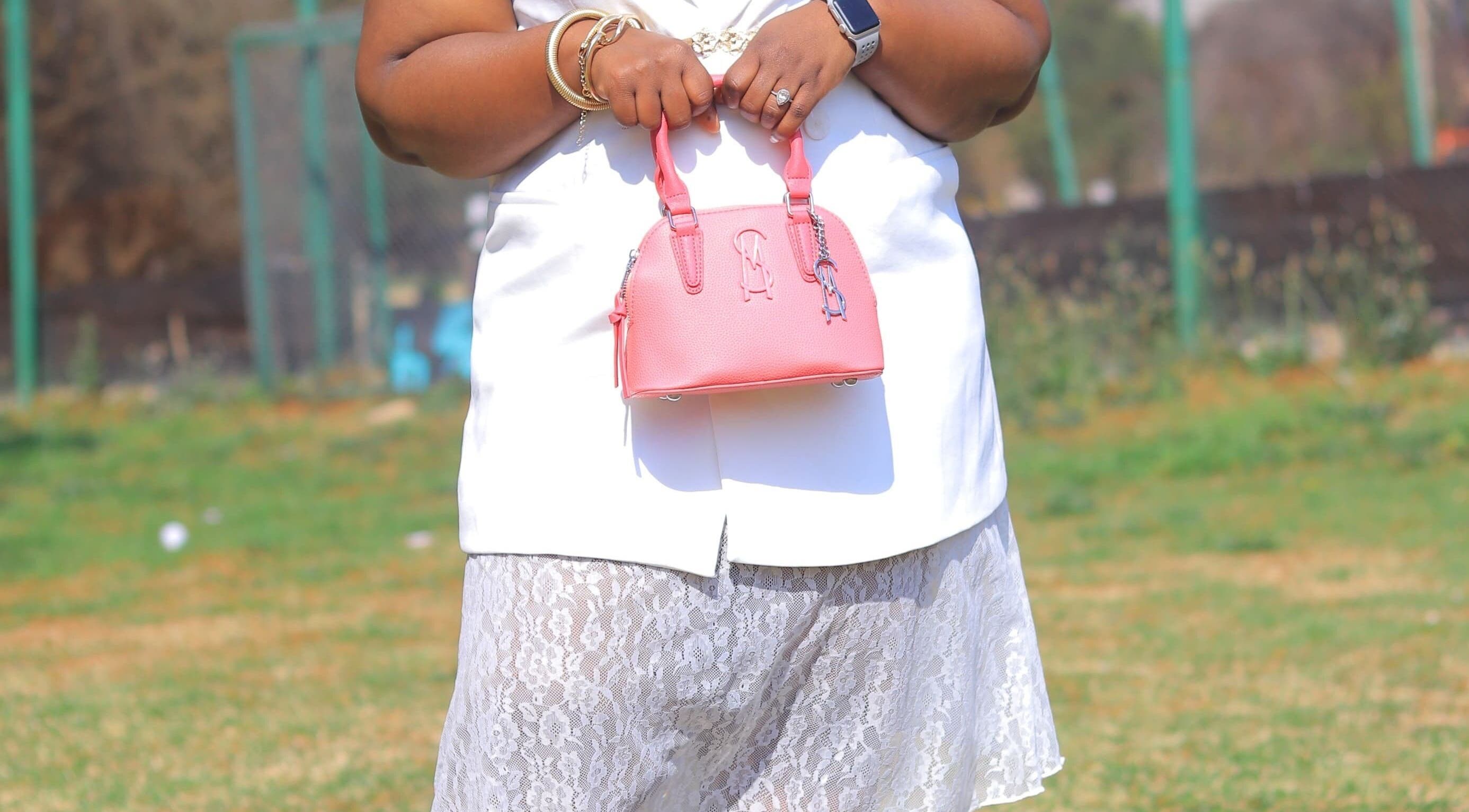 A woman holds a pink handbag at Brushed Nails by Nqobi in Johannesburg, Gauteng, ZA.