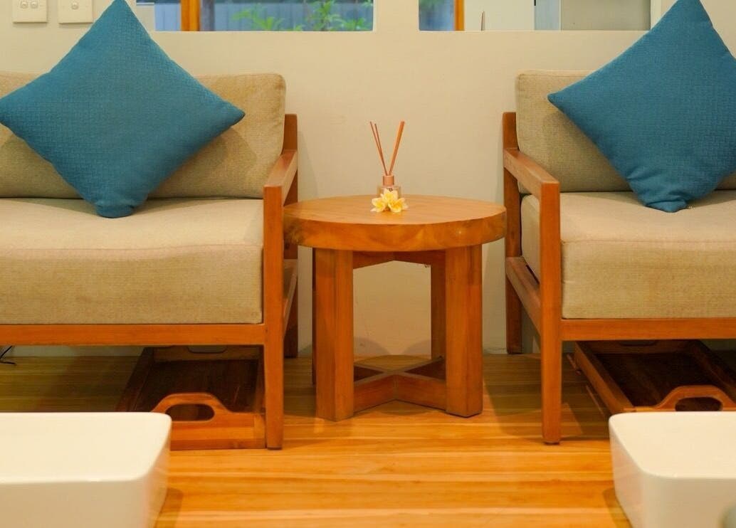Relaxing seating area at KU Salon & Spa, Nusa Tenggara Barat, with plush cushions and wooden decor.