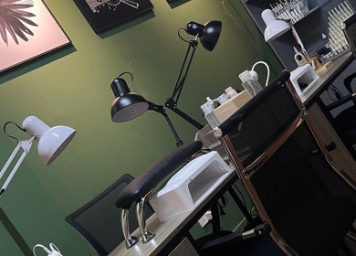 Bàn làm móng sang trọng tại Redpetals.studio, Hà Nội, Hà Nội, VN với đèn chiếu sáng hiện đại và dụng cụ.