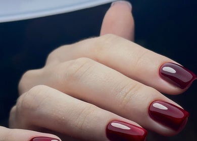 Bàn tay với móng tay đỏ bóng tại Redpetals.studio, Hà Nội, Hà Nội, VN, thể hiện sự tinh tế và phong cách.