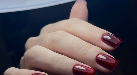 Bàn tay với móng tay đỏ bóng tại Redpetals.studio, Hà Nội, Hà Nội, VN, thể hiện sự tinh tế và phong cách.