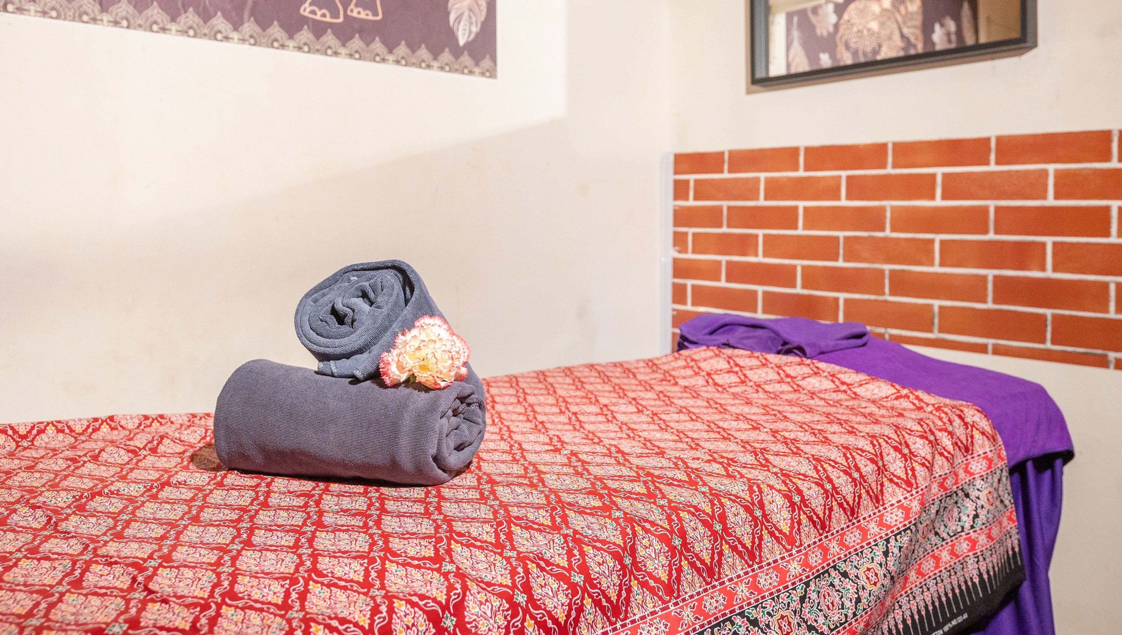 Serene massage bed with neatly rolled towels at Thai Time Wellness Spa, Singapore, Singapore, SG.