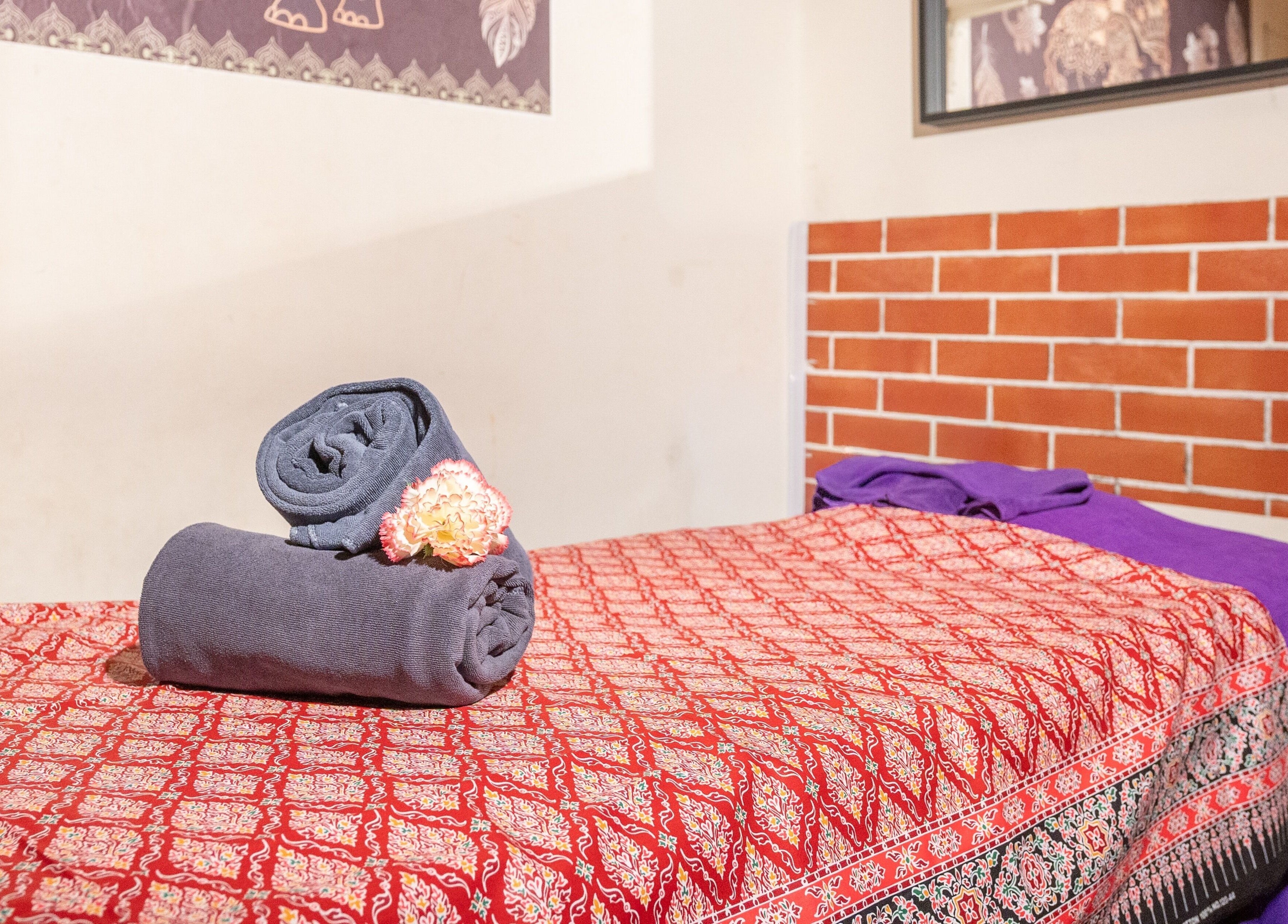 Serene massage bed with neatly rolled towels at Thai Time Wellness Spa, Singapore, Singapore, SG.