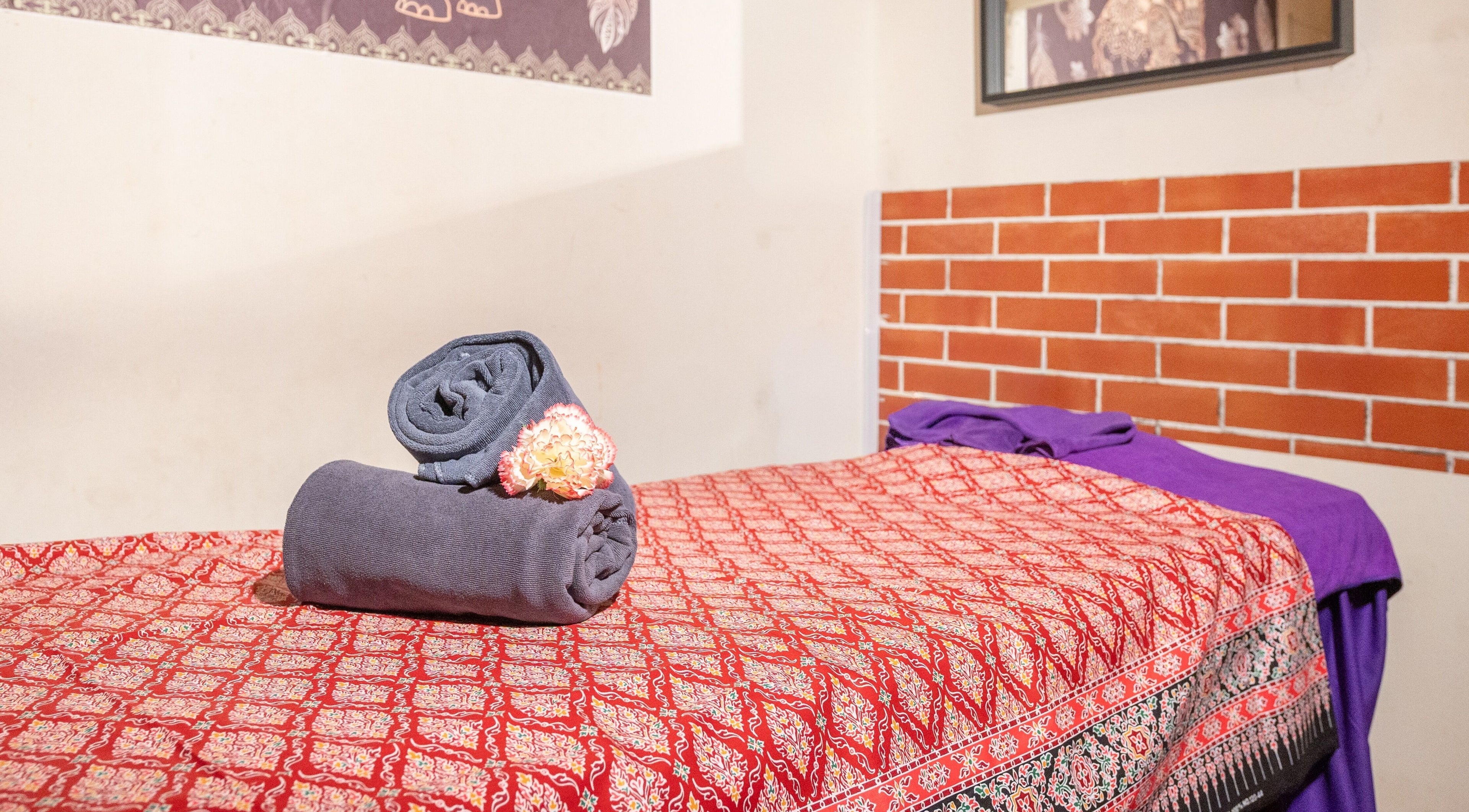 Serene massage bed with neatly rolled towels at Thai Time Wellness Spa, Singapore, Singapore, SG.