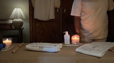 Calming massage setup at Home Services, Al Hayathem, Riyadh Province, SA with candles and therapeutic oils.