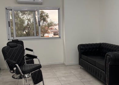 Interior moderno de Berlín Estudio en Lanús, Provincia De Buenos Aires, AR, con sillones elegantes y amplio ventanal.