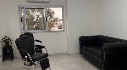 Interior moderno de Berlín Estudio en Lanús, Provincia De Buenos Aires, AR, con sillones elegantes y amplio ventanal.